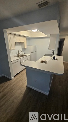 A kitchen with white cabinets and a white island.