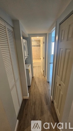 A hallway with white doors and a wooden floor.