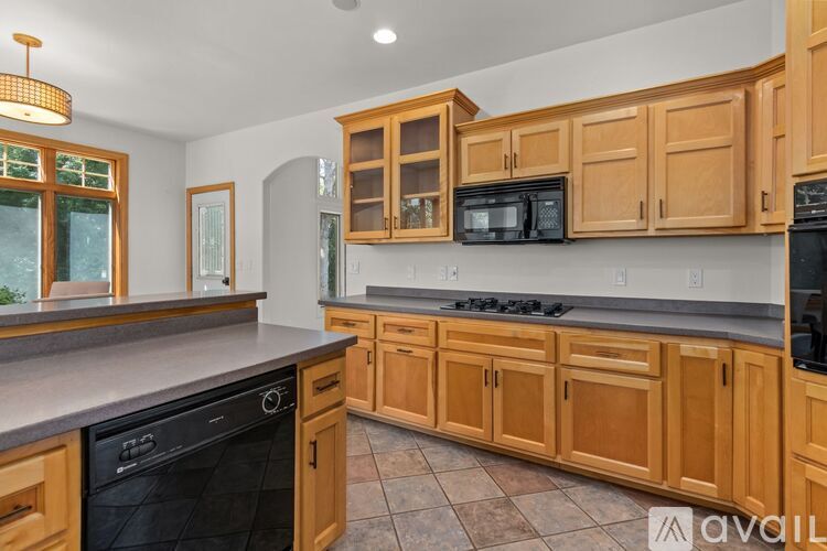 A kitchen with wooden cabinets and a black oven.