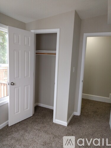 A room with a white door and a carpeted floor.