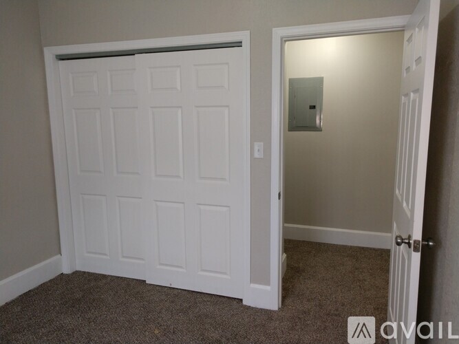 A white door with a mirror on the wall.