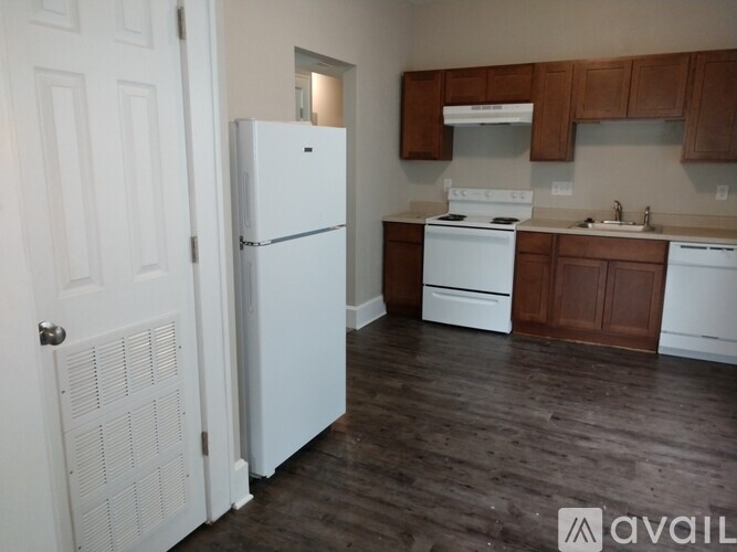A kitchen with white appliances and wooden cabinets.