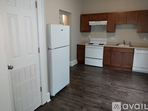 A kitchen with white appliances and wooden cabinets.