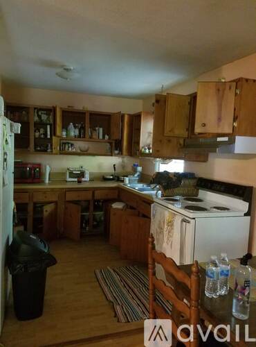 A kitchen with wooden cabinets and a white stove.