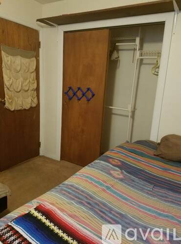 A bedroom with a bed and a wardrobe.
