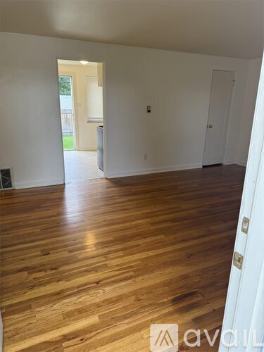 A room with wooden flooring and white walls.