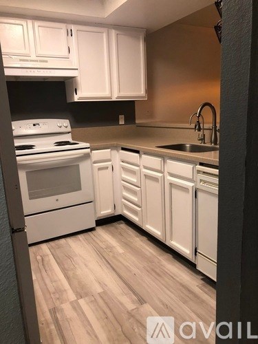 A kitchen with white cabinets and a stove top oven.