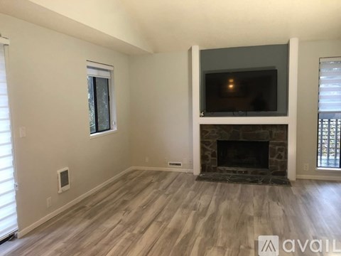 A living room with a fireplace and a flat screen TV mounted above it.
