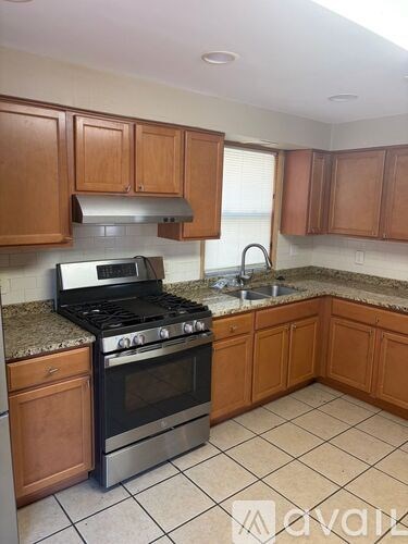 A kitchen with wooden cabinets and a granite countertop.