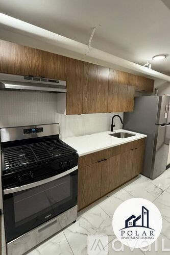 A kitchen with wooden cabinets and a stove top oven.