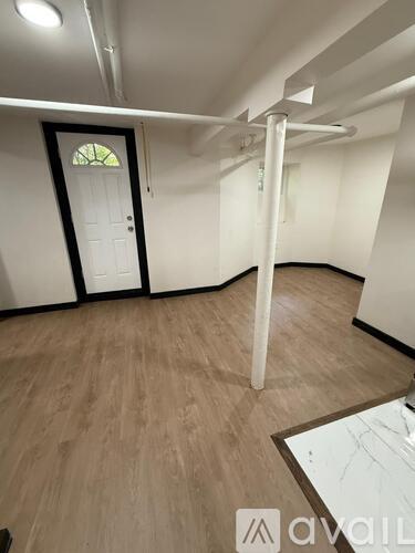 A room with a white door and a wooden floor.