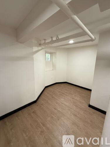 A room with wooden flooring and white walls.