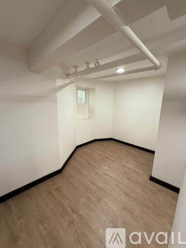 A room with wooden flooring and white walls.
