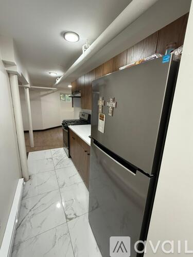 A kitchen with a refrigerator, sink, and countertops.
