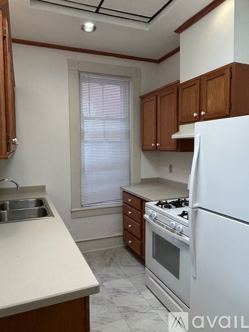 A kitchen with white appliances and wooden cabinets.