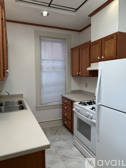 A kitchen with white appliances and wooden cabinets.