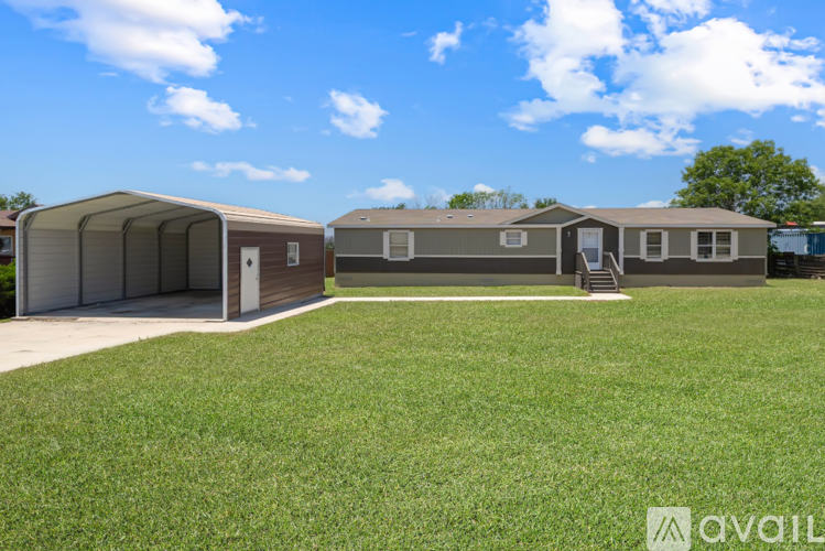 A row of mobile homes with a grassy area in front.