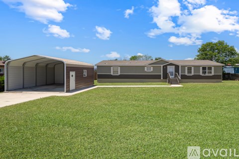A row of mobile homes with a grassy area in front.
