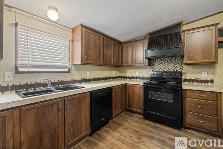 A kitchen with wooden cabinets and a black stove top oven.