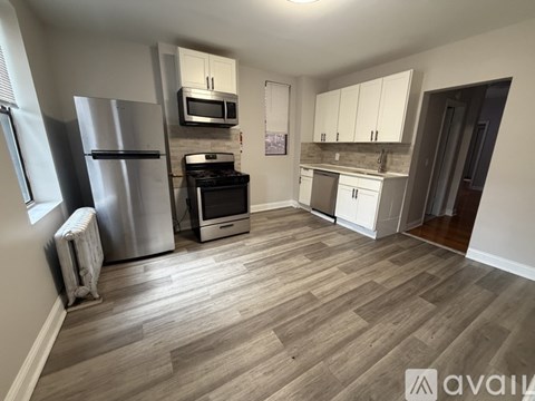 A kitchen with a refrigerator, oven, and microwave.