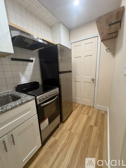 A kitchen with a black oven and white cabinets.