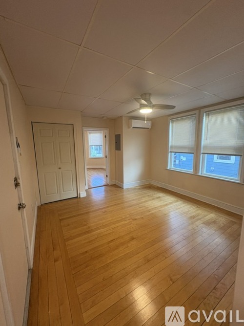 A room with wooden flooring and a ceiling fan.