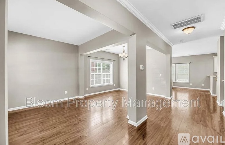 A spacious room with wooden floors and a window is available for rent.
