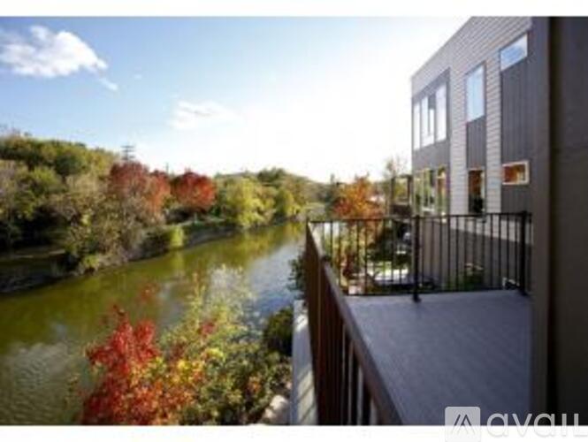 A balcony overlooks a river with autumn trees.