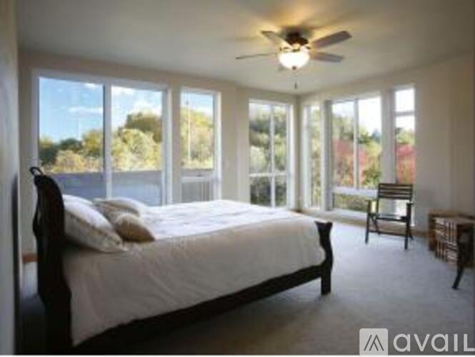 A bedroom with a large bed and a ceiling fan.