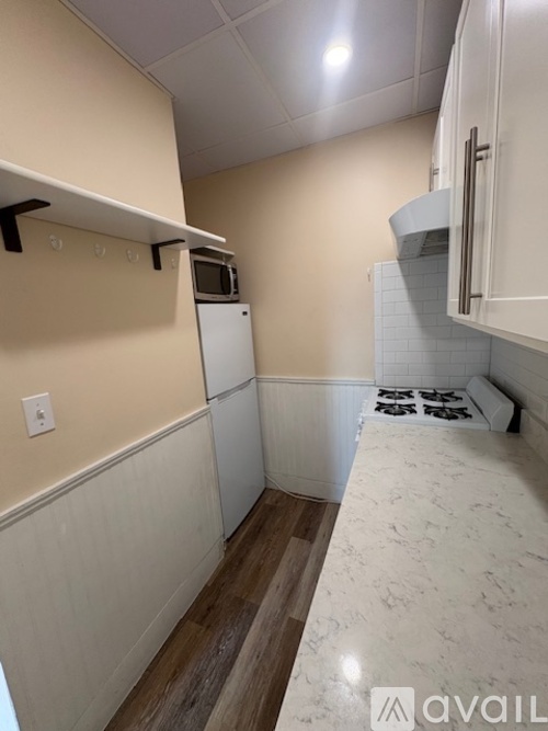 A kitchen with white cabinets and a white counter top.