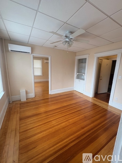 A room with wooden flooring and a ceiling fan.