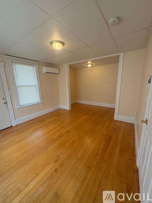 A room with wooden flooring and white walls.