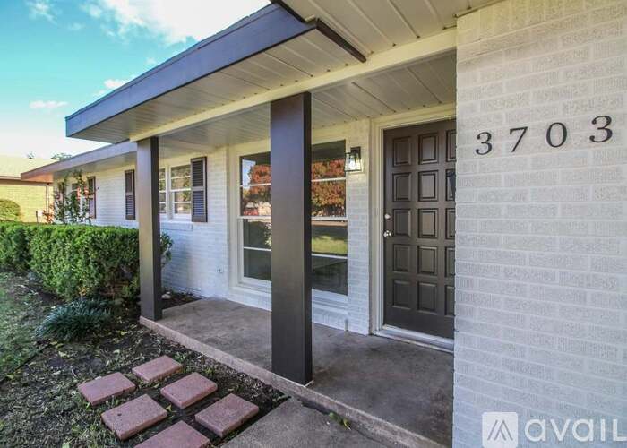 A house numbered 3703 with a porch and a brick walkway.