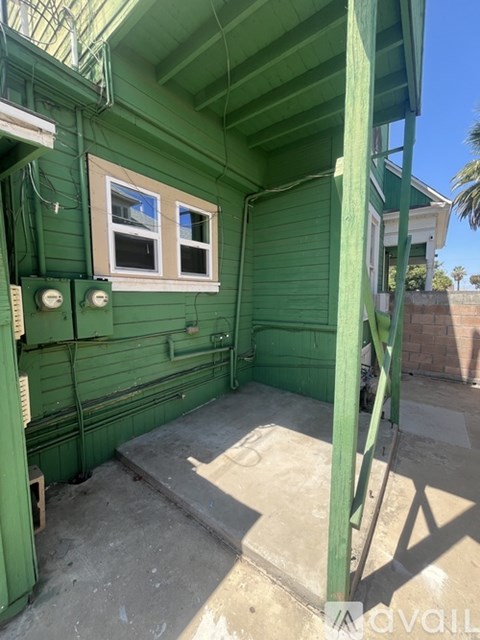 A green house with a window and a door.