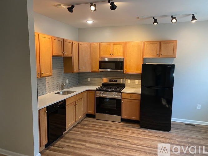 A kitchen with wooden cabinets and black appliances.