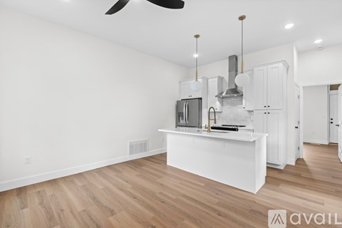 A kitchen with white cabinets and a wooden floor.