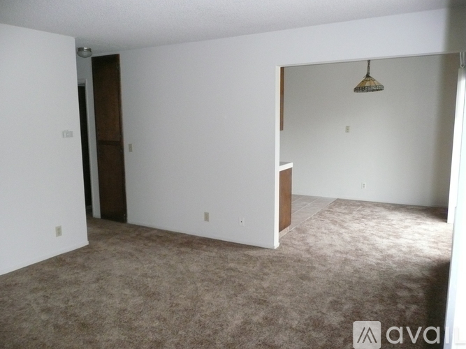 A room with carpeted floor and a ceiling fan.