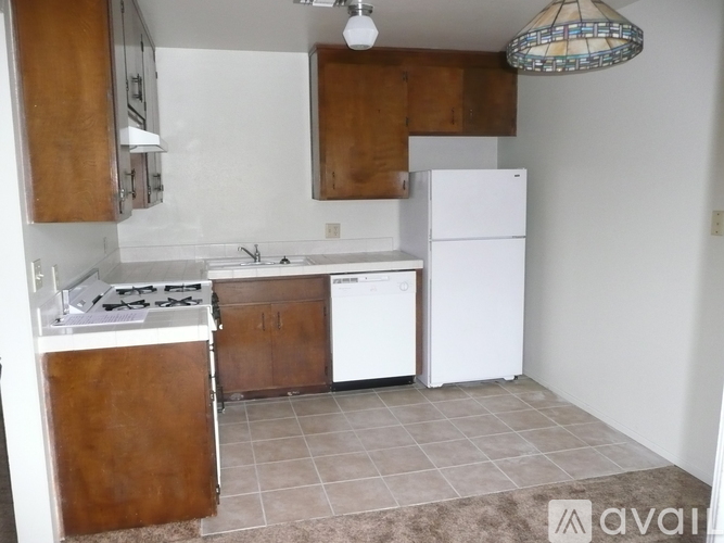 A kitchen with white appliances and brown cabinets.