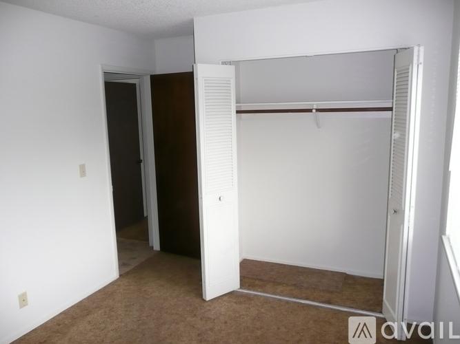 A bedroom with a brown carpet and a white door.