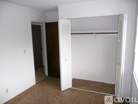A bedroom with a brown carpet and a white door.