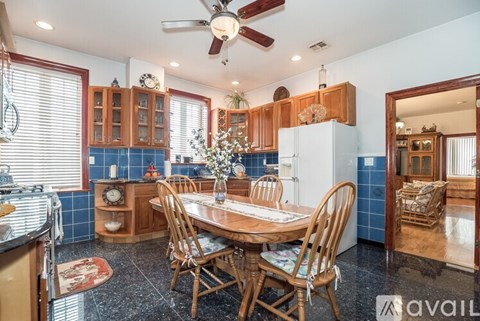 A kitchen with a table and chairs in the middle.