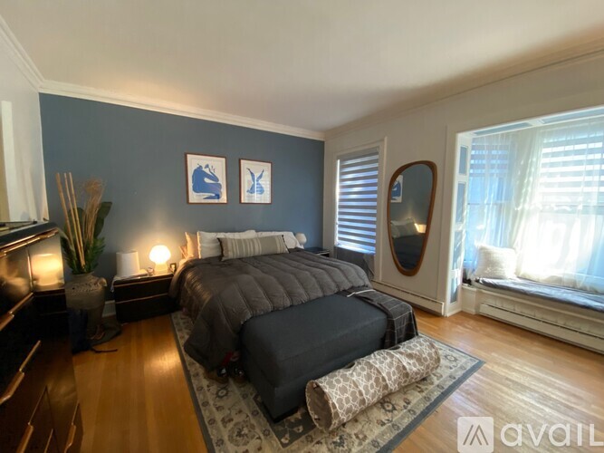 A bedroom with a large bed and a mirror on the wall.