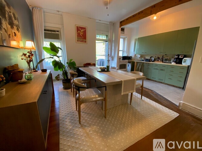 A kitchen with green cabinets and a dining table with chairs.