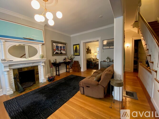 A living room with a fireplace and a black rug.