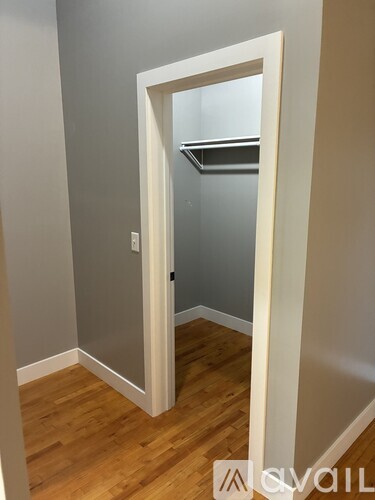A white doorway leads to a small bathroom.