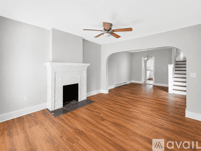 A living room with a fireplace and a ceiling fan.