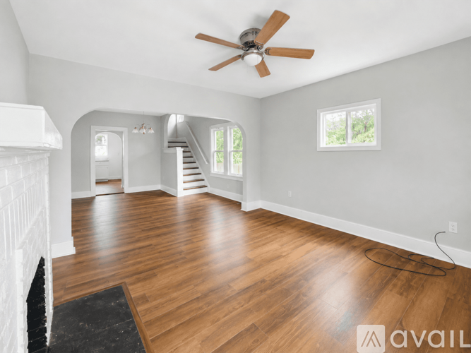 A spacious room with a ceiling fan and wooden flooring.