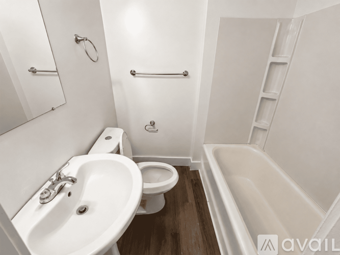 A white bathroom with a toilet, sink, and bathtub.