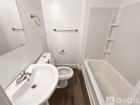 A white bathroom with a toilet, sink, and bathtub.