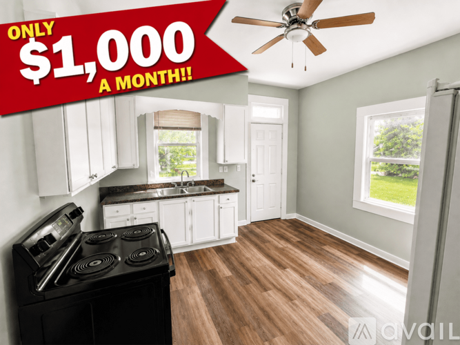 A kitchen with a stove top oven and a ceiling fan.